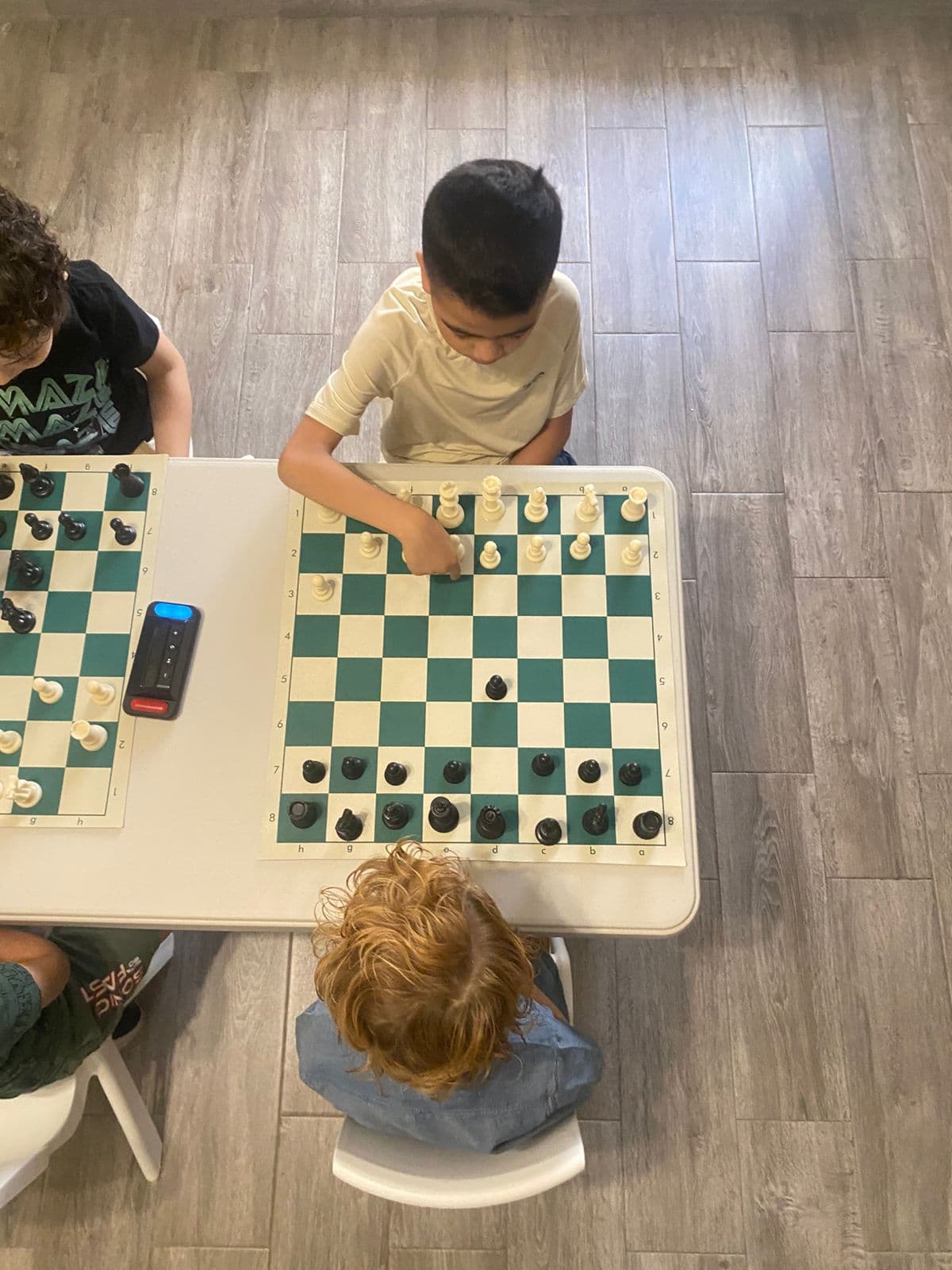 Niños jugando ajedrez en una clase de POLGAR
