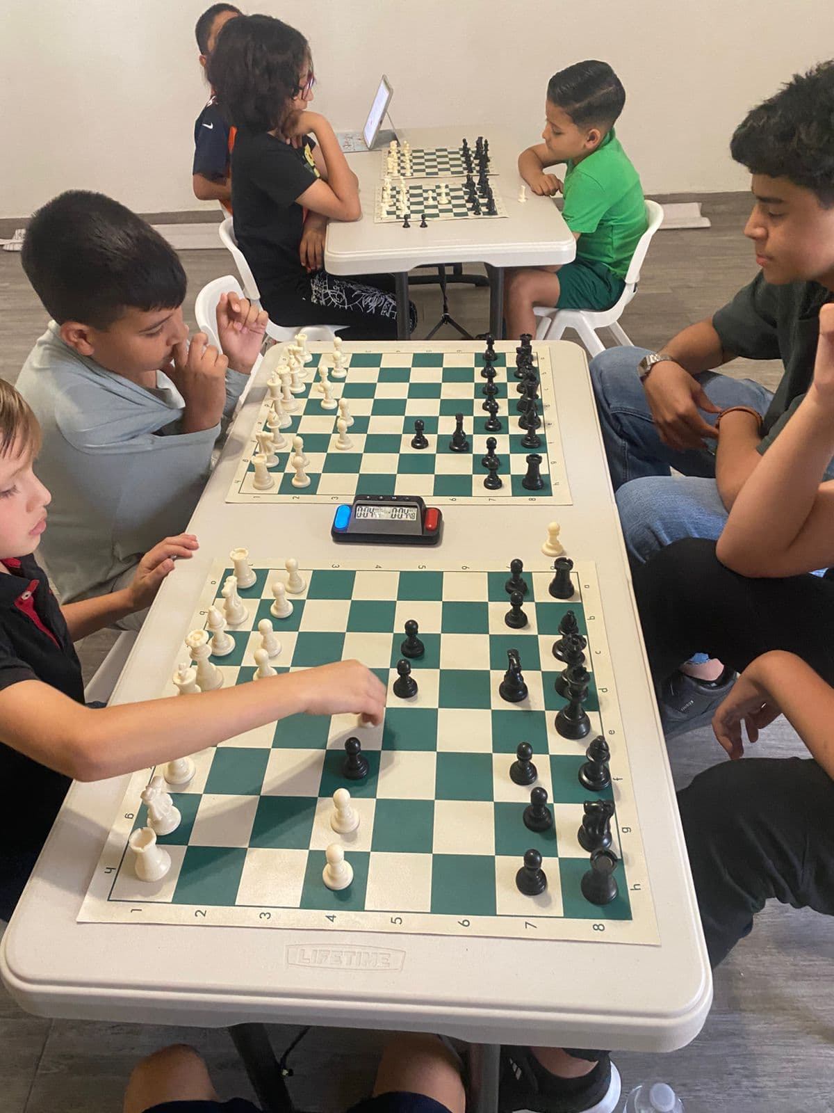 Grupo de niños jugando ajedrez en clase